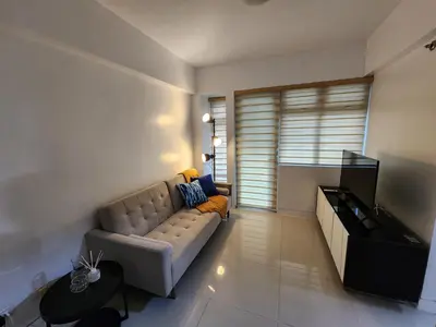 a living room with a couch and a flat screen tv at 1BR Condo w Balcony near NAIA, Casino, Newport in Manila