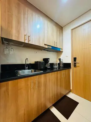 a kitchen with wooden cabinets and a sink at RED RESIDENCES Makati in Manila