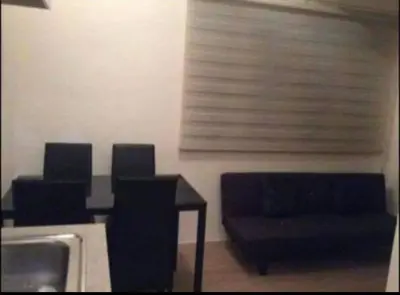 a dining room with a table and chairs and a sink at Laureano di trevi tower condominium Corporation in Manila