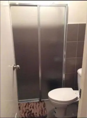 a shower stall in a bathroom with a toilet at Laureano di trevi tower condominium Corporation in Manila