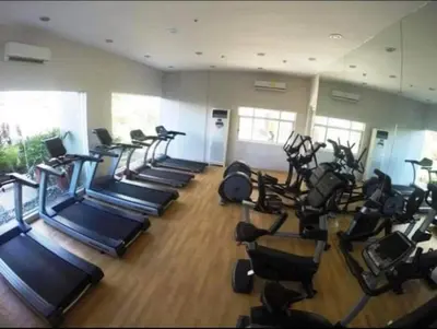 a gym with a row of treadmills and exercise machines at Laureano di trevi tower condominium Corporation in Manila