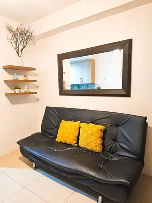 a black leather couch in a living room with a mirror at Tokyo Oasis at Shore 1 Residences Tower A, Pasay, MOA in Manila