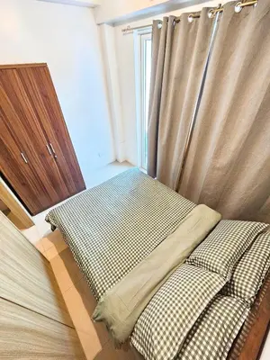 two beds in a room with a window at Tokyo Oasis at Shore 1 Residences Tower A, Pasay, MOA in Manila