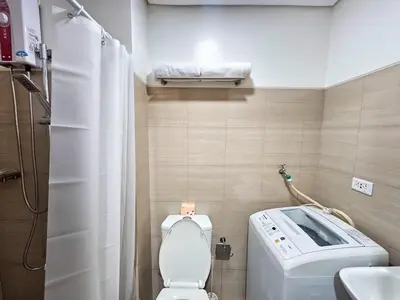 a small bathroom with a toilet and a washing machine at Tokyo Oasis at Shore 1 Residences Tower A, Pasay, MOA in Manila