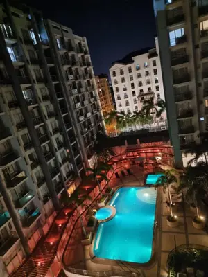 a swimming pool in the middle of some buildings at One Palm Tree Villas in Manila