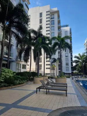 two park benches in front of a building with palm trees at One Palm Tree Villas in Manila