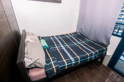 a small bed in the corner of a room at Cozy Crash Pad B Laughter friendly Makati 2271 Gym Swim Park 300 in Manila