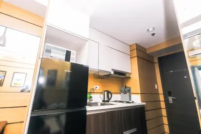 a kitchen with a black refrigerator and a sink at Hidden Gem Coolest Crash spot Makati Swim Gym Park 2320 in Manila
