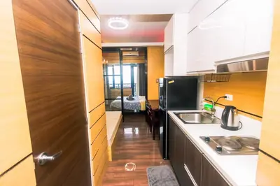 a kitchen with a refrigerator and a sink and a door at Hidden Gem Coolest Crash spot Makati Swim Gym Park 2320 in Manila