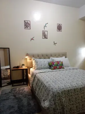 a bedroom with a bed and birds on the wall at 101 Newport in Manila