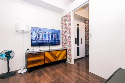 a living room with a flat screen tv on a wall at Royal Polo club Air condo Makati Swim Gym Park 300 mbps in Manila