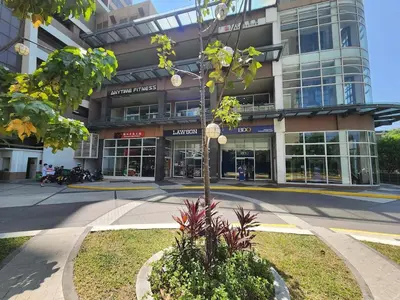 a building with a tree in front of a street at Radiance Manila Bay in Manila