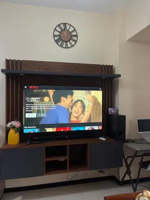a flat screen tv sitting in a living room at BayFront 1BR Condo in Pasay with FREE Wi-Fi, Netflix, Pool Access & Gym, Near NAIA Airport, MOA, OKADA, CCP & PICC in Manila
