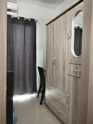 a wooden cabinet with a mirror and a chair in a room at VSV Luxury Family Suite staycation Moa shore2 tower2 unit1122 in Manila