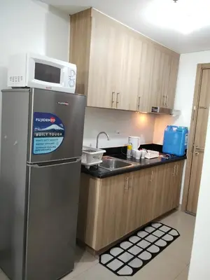 a kitchen with a microwave on top of a refrigerator at VSV Luxury Family Suite staycation Moa shore2 tower2 unit 1122 in Manila