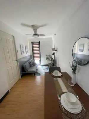 a living room with a table and a mirror at Cozy 1 Bedroom Unit Arezzo Place Pasig in Pasig