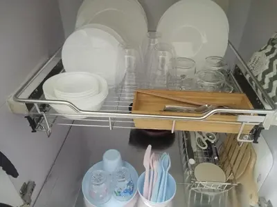 a shelf in a kitchen with plates and utensils at Condo sa south residences tower 3 in Manila