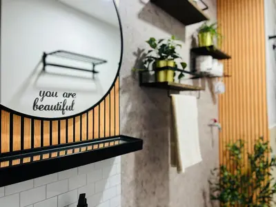 a bathroom with a mirror and plants on the wall at CityZen Suite in Trece Martires