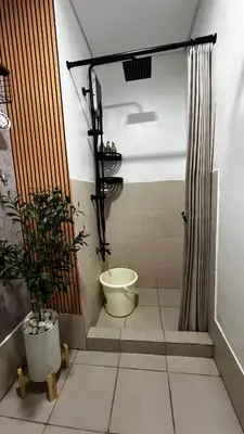 a bathroom with a shower with a toilet and a plant at CityZen Suite in Trece Martires