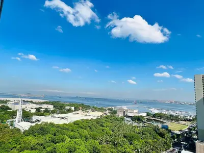 a view of a city and the ocean from a building at D Crib at Breeze Residences Pasay City Philippines in Manila