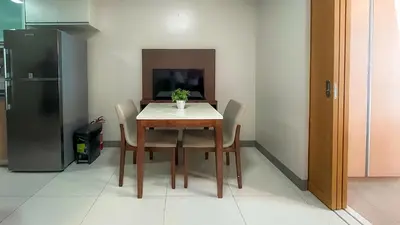 a table and chairs in a kitchen with a refrigerator at Full-Serviced Residential Apartment in One Uptown Residences, BGC in Manila