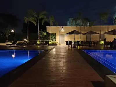 a pool at night with tables and umbrellas at Tulip Garden Condominium Southwoods in Biñan