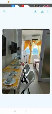 a dining room with a long table and chairs at Shell Condotel MOA Pasay in Manila