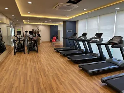a gym with a row of treadmills and exercise bikes at Tulip Garden condo in Biñan