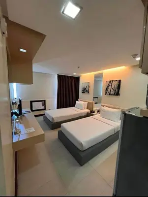 a hotel room with two beds and a desk at Spacious Cozy Corner in Manila