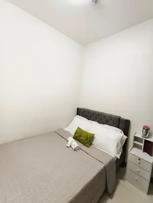 a small bedroom with a bed with white pillows at Escape To Paradise in Manila