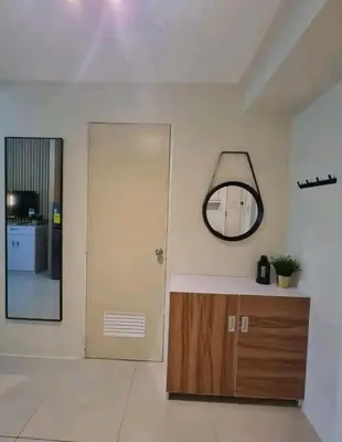 a room with a mirror and a cabinet and a door at Cozy Room At Sea Residences in Manila