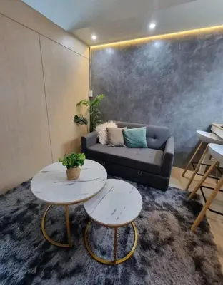 a living room with a couch and two tables at Cozy Room At Sea Residences in Manila