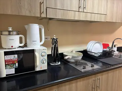 a kitchen counter with a coffee maker and a microwave at Manila Shore Residences Tower D MOA in Manila