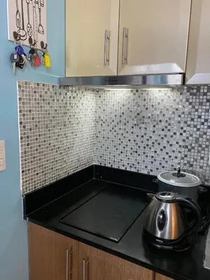 a kitchen with a stove with a tea pot on the counter at Cozy Home Right Across International Airport Terminal 3 in Manila