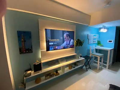 a living room with a flat screen tv on a wall at Cozy Home Right Across International Airport Terminal 3 in Manila