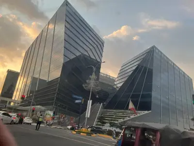 a large glass building with cars parked in front of it at Bayshore 2 Okada Bayview WiFi Big TV Netflix Near NAIA&MOA in Manila
