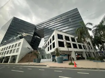 a building on a street with palm trees in front of it at Bayshore 2 Okada Bayview WiFi Big TV Netflix Near NAIA&MOA in Manila