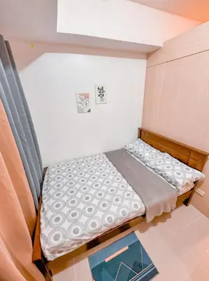 a small bed in a small room with a glass table at Aeva's Cozy Stay in Manila