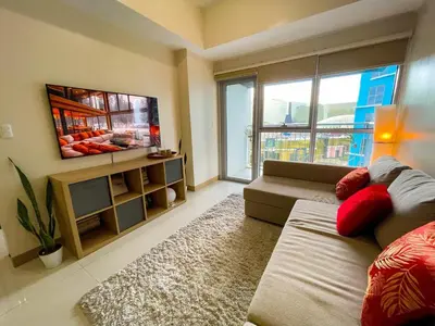 a living room with a couch and a large window at Exquisite 2BR Corner Suite with Sunset, Okada View in Manila