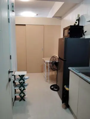 an empty kitchen with a refrigerator and a table at Condo sa south residences tower 3 in Manila