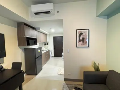 a living room with a couch and a kitchen at Elegant 1 bedroom apartment with great facilities and perfect location in Manila