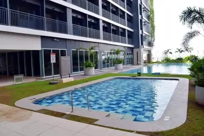 a swimming pool in front of a building at HyrCondotel in Manila