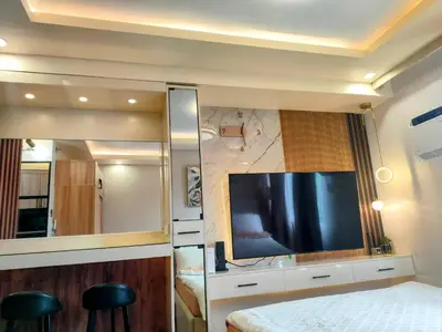 a bedroom with a tv and a bed with stools at The Solace Place- Near Nuvali Sta Rosa Laguna in Bayabasan