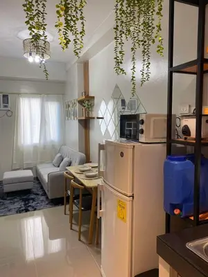 a kitchen and living room with a refrigerator and a table at R and A Enclave in Manila