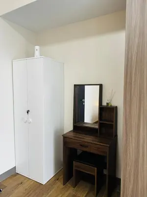 a dressing room with a mirror and a wooden dresser at 7FF Cozy 1BR Park McKinley West near BGC & Venice Mall in Manila