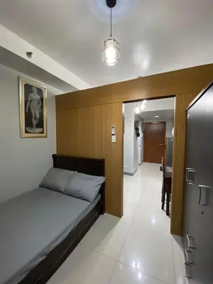 a bedroom with a bed and a hallway with a table at Great Price and Location in Moa, Pasay City, Philippines in Manila