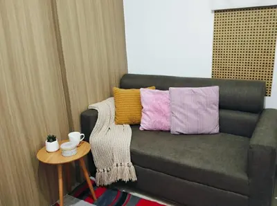 a living room with a couch with colorful pillows at Mall of Asia - Aseana Residences SHORE APARTMENTS in Manila