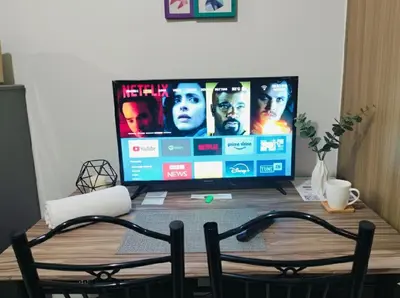a television sitting on a wooden table with two chairs at Mall of Asia - Aseana Residences SHORE APARTMENTS in Manila