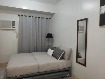 a small bedroom with a bed and a mirror at 2019 Cavite Green 2 Condo Amenities HI Speed Wifi in Dasmariñas