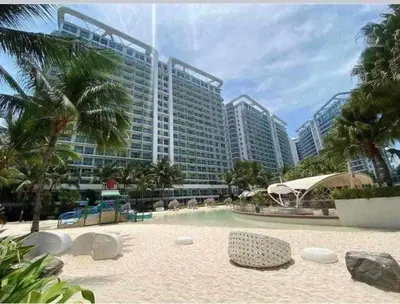 a resort with a swimming pool and a large building at Maldives Tower Azure in Manila